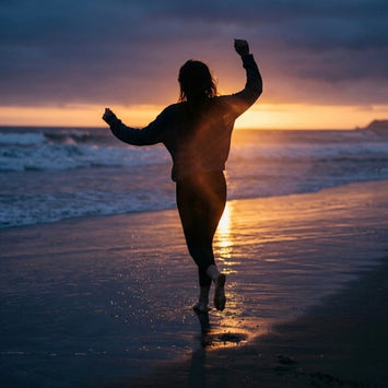 Woman dancing on a beach at sunset