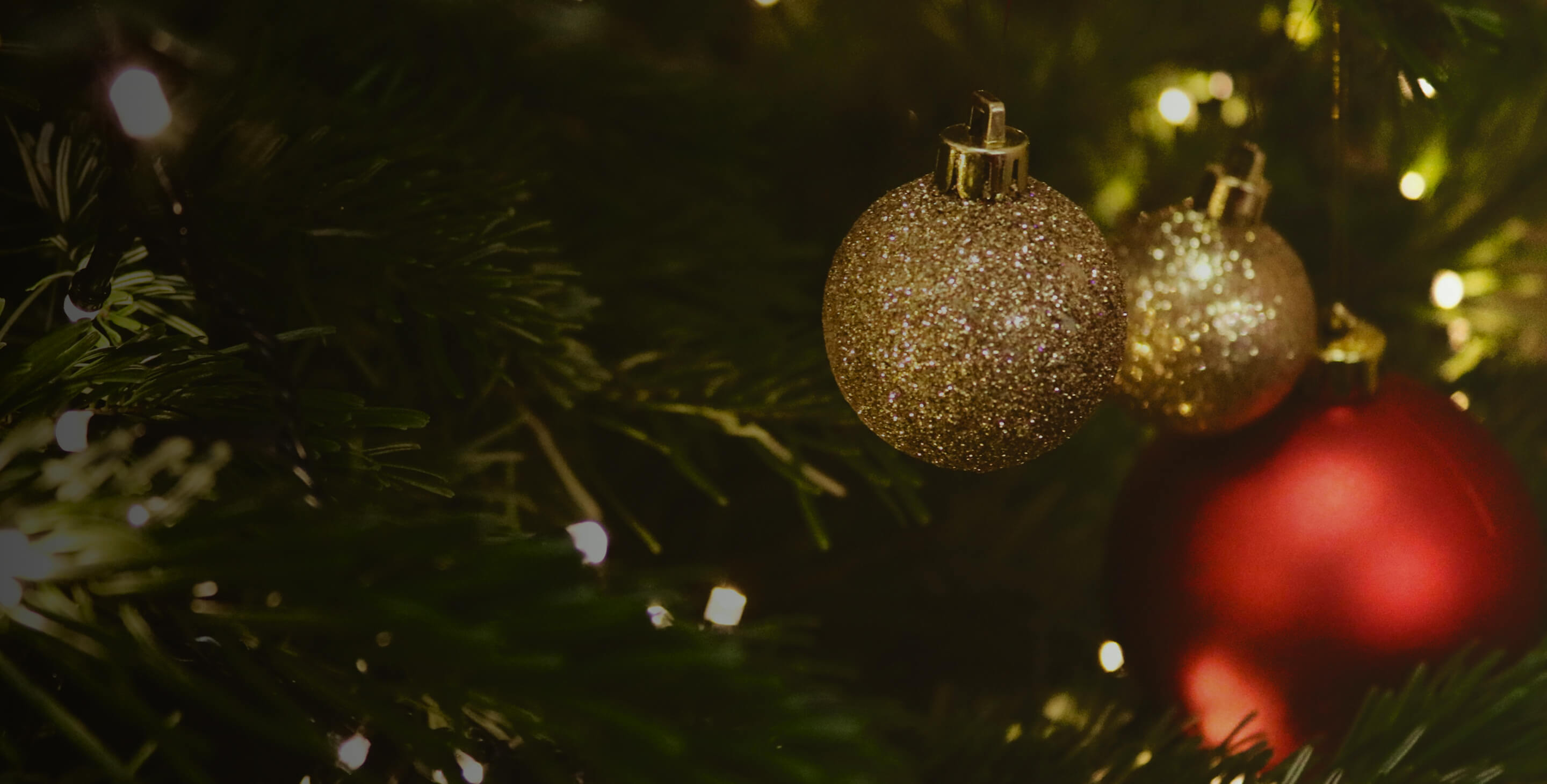 Decorative Christmas tree with gold and red ornaments and twinkling lights.