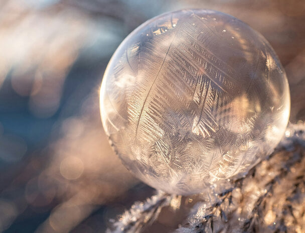 Clear crystal ball with engraved text on a natural background